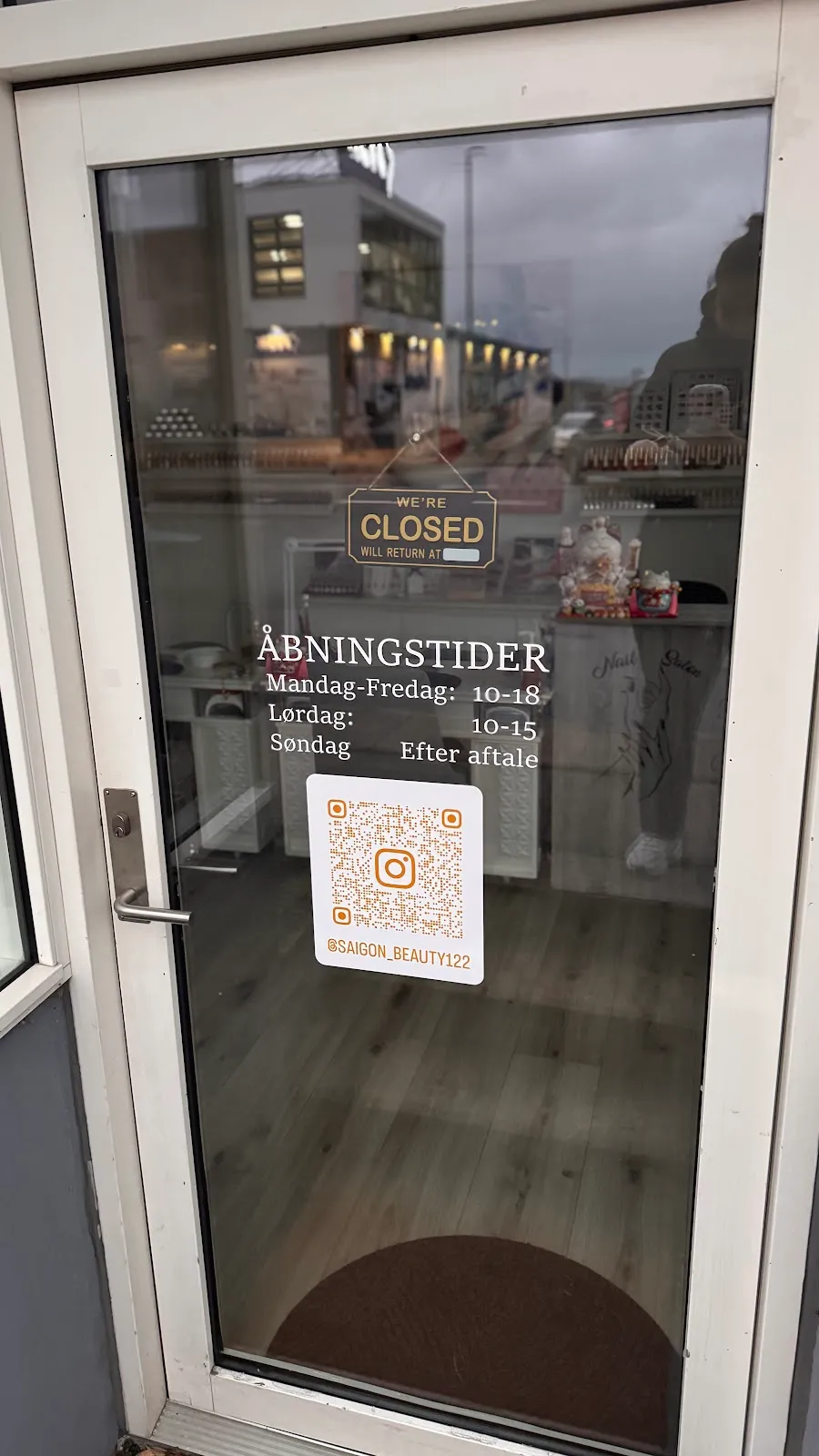 Indgangsdøren hos Saigon Beauty med åbningstider og Instagram QR kode